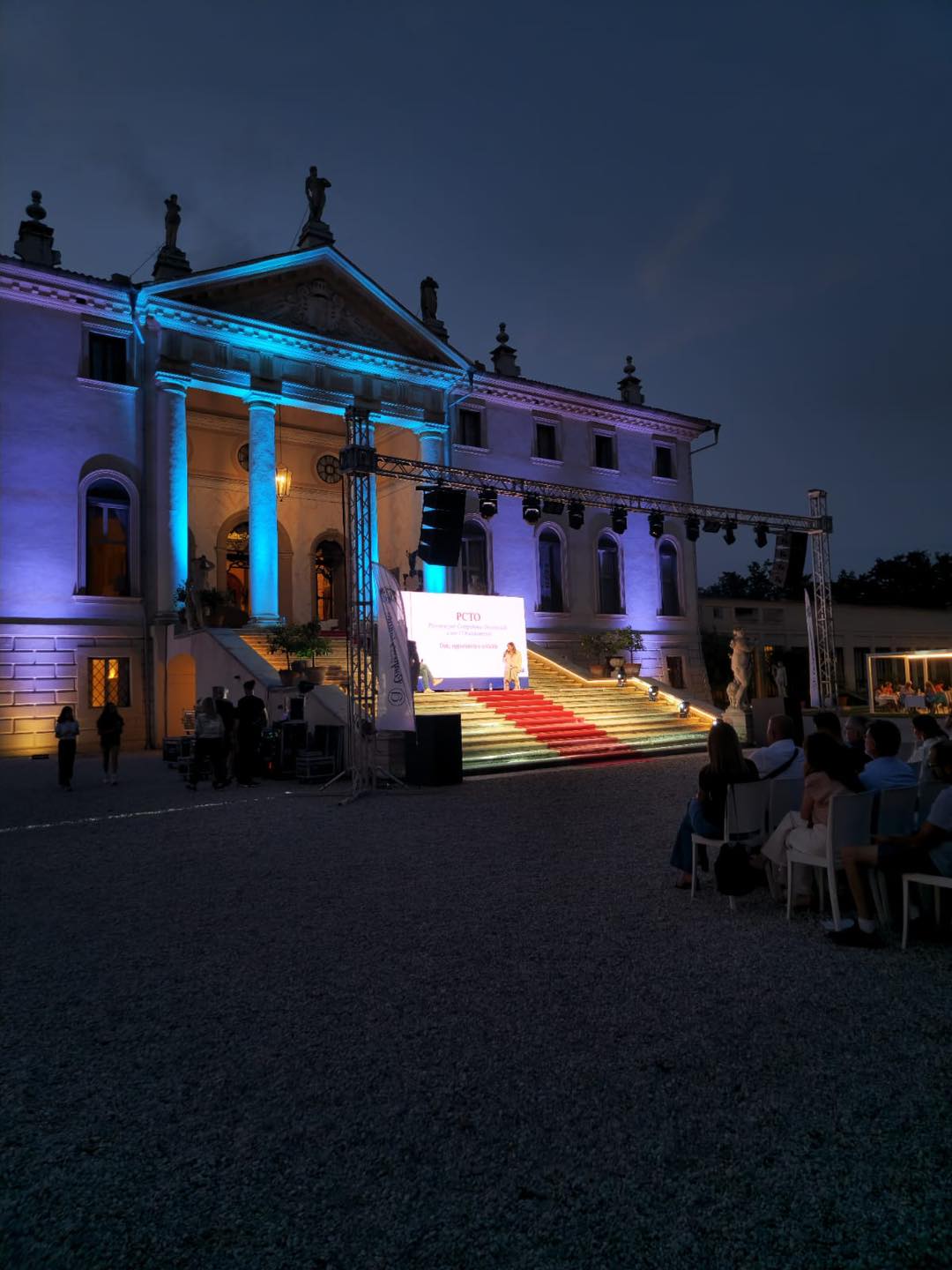 Serata in villa: facciata illuminata, palco e schermo